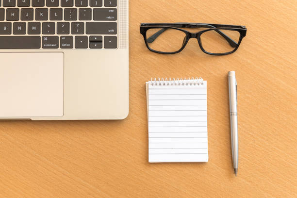 istock Top view desk with notepad and laptop on office wooden table 1221969318