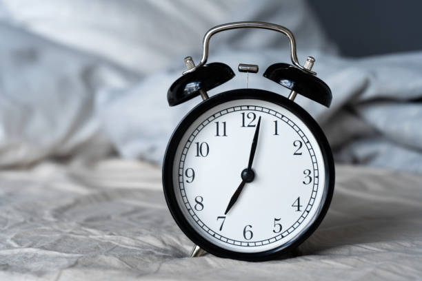 istock Stylish alarm clock with a bell. The hands show 7 hours. Wake up time 1221970584