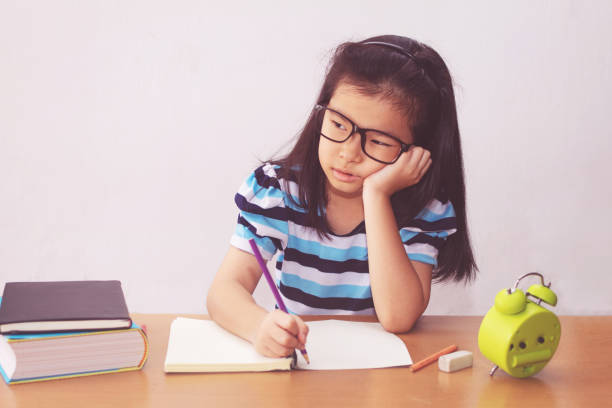 istock Bored and tired asian student girl doing homework 1221970681