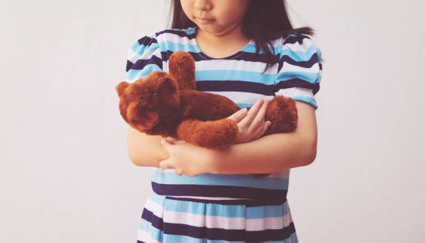istock asia girl hugging a teddy bear 1221970686