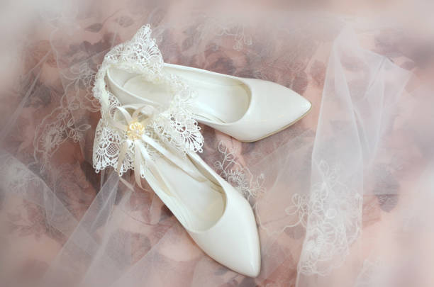 istock White wedding shoes and the bride's garter on a blurry background 1221971087