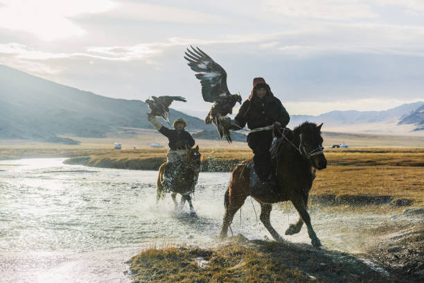 istock Eagle hunters riding through  the river in Mongolia 1221974042