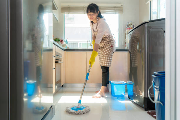istock Attractive young Asian woman Mopping the kitchen floor at kitchen while doing cleaning at home during Staying at home using free time about their daily housekeeping routine. 1221974616