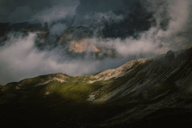 A long distance landscape of steep French Alps surrounded by cloud stock photo