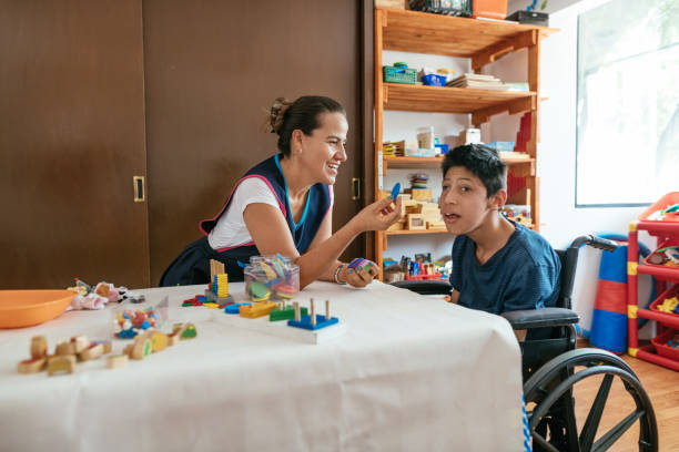 istock Mother teaching her son with cerebral palsy at home during coronavirus pandemic 1221978604