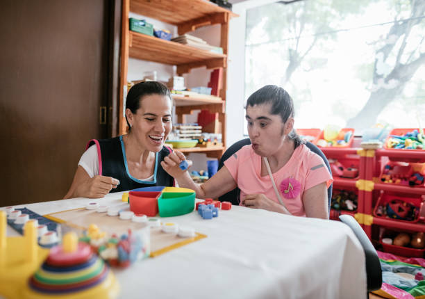 istock Parent helping disabled child to improve physical skills 1221978650
