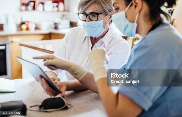 District Nurse At Home Visit Stock Photo - Download Image Now - Healthcare And Medicine, Technology, Protective Face Mask