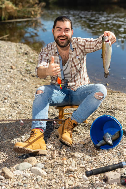istock Lucky fisherman caught a trout fish 1221980566