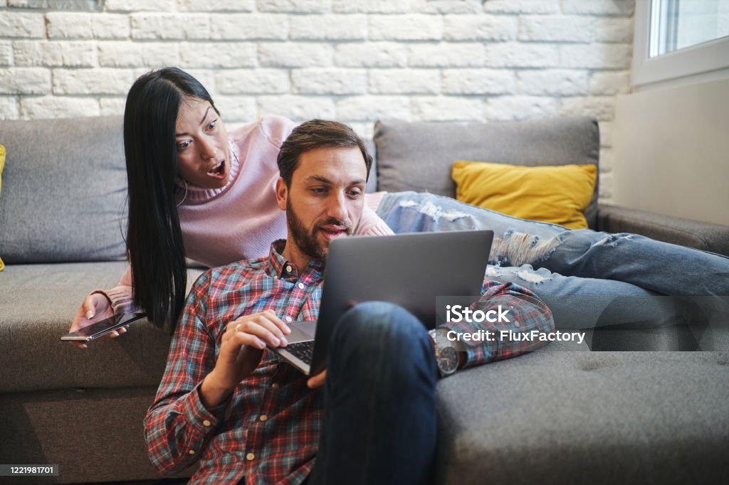 Charming Married Couple Looking At Funny Video Clips On Internet And Having  Some Amazing Time Together In The Morning Stock Photo - Download Image Now  - iStock