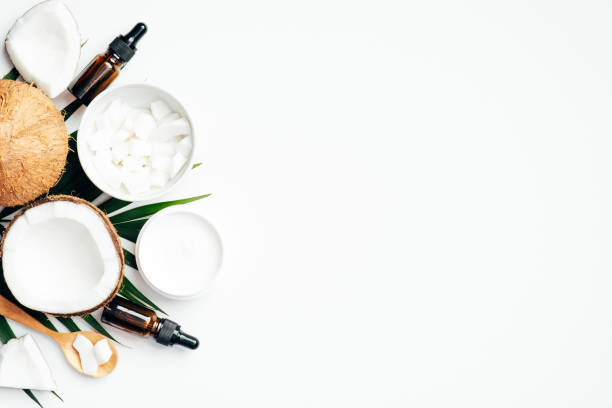 istock Flat lay composition with coconut oil and body cream with tropical palm leaf on white background. Flat lay, top view. SPA natural organic cosmetic for skin care, body treatment concept 1221982971