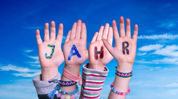 istock Children Hands Building Word Jahr Means Year, Blue Sky 1221984575
