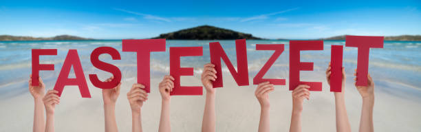 istock People Hands Holding Word Fastenzeit Means Fasting, Ocean Background 1221986292