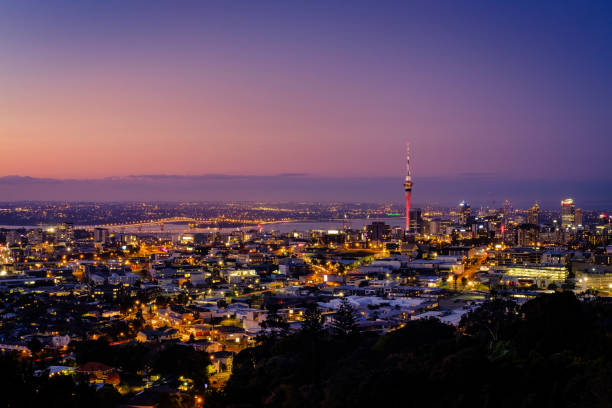 Auckland City Skyline At Sunset From Mount Eden / Maungawhau View of Auckland City including the Sky Tower and Harbour Bridge from Mount Eden at sunset. auckland stock pictures, royalty-free photos & images