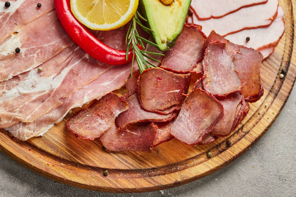 istock Appetizer from different types of meat delicacies such as  basturma, prosciutto crudo or spanish jamon and salami . A dish for a banquet 1221989723
