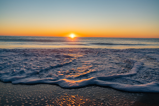 Sunrise over the Atlantic. Water receding at Carolina Beach, North Carolina.