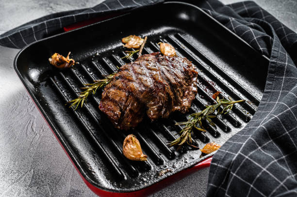 Grilled Top Blade steak on a grill pan, marbled beef. Gray background. Top view Grilled Top Blade steak on a grill pan, marbled beef. Gray background. Top view. blade roast stock pictures, royalty-free photos & images