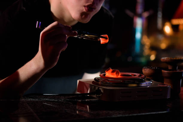 istock Shisha hookah, red hot coals. Man blows coals for sparks fly. 1221991261