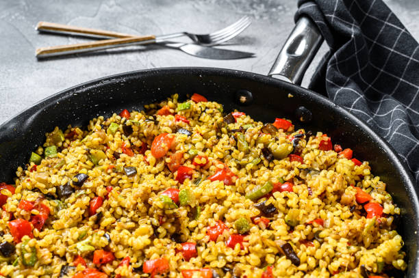 istock Cooked bulgur with vegetables and chicken meat in a pan. Gray background. Top view 1221991319