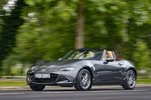 Zagreb, Croatia - April 22, 2018: Man is driving Mazda MX-5 aka Miata fast on the road. This iconic Japanese sports roadster became very popular in the eighties because it was affordable.