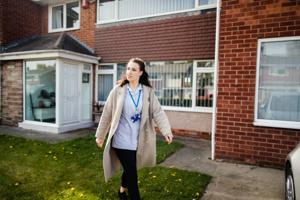 Off to Work A female healthcare worker leaving the house in her uniform. She is off to work for the NHS. day in the life stock pictures, royalty-free photos & images