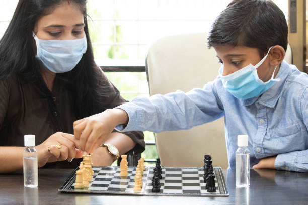 mère et fils jouant aux échecs à la maison - chess skill concentration intelligence photos et images de collection