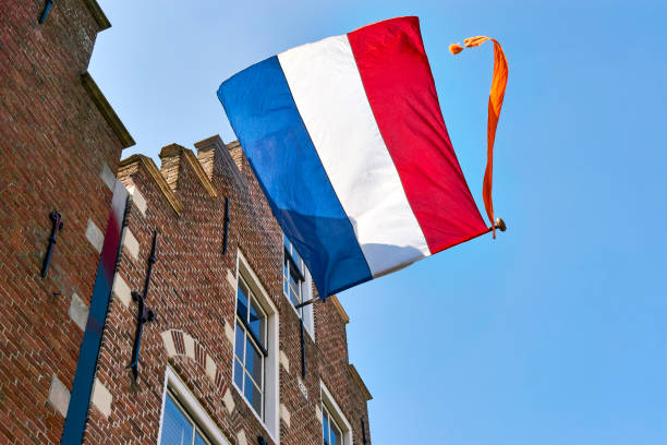 голландский флаг с оранжевым растяжкой на фасаде голландского дома в день короля - brick european culture facade famous place стоковые фото и изображения