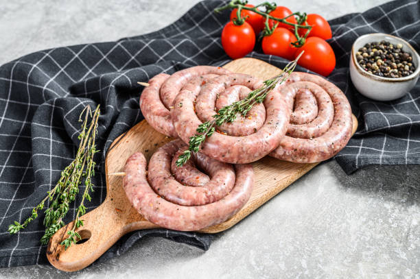istock Fresh raw spiral chicken sausages. Gray background. Top view 1221996940