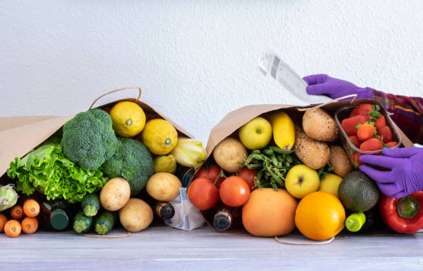 a idosa que usa luvas de proteção recebe comida e bebida em um saco de papel para pessoas em quarentena para a pandemia de coronavírus covid-19. fique em casa conceito - zucchini vegetable food food and drink - fotografias e filmes do acervo