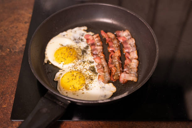 tasty bacon stripes lies on fried eggs