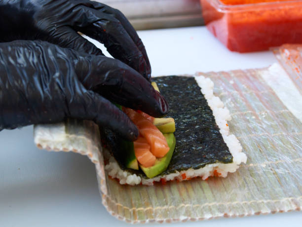 istock Cook hands making Philadelphia sushi roll closeup photo 1222002124