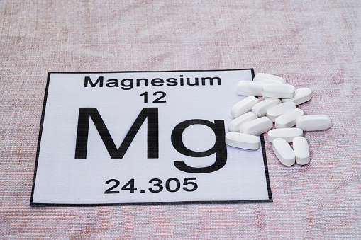 Magnesium supplement pills placed on a Periodic table tile