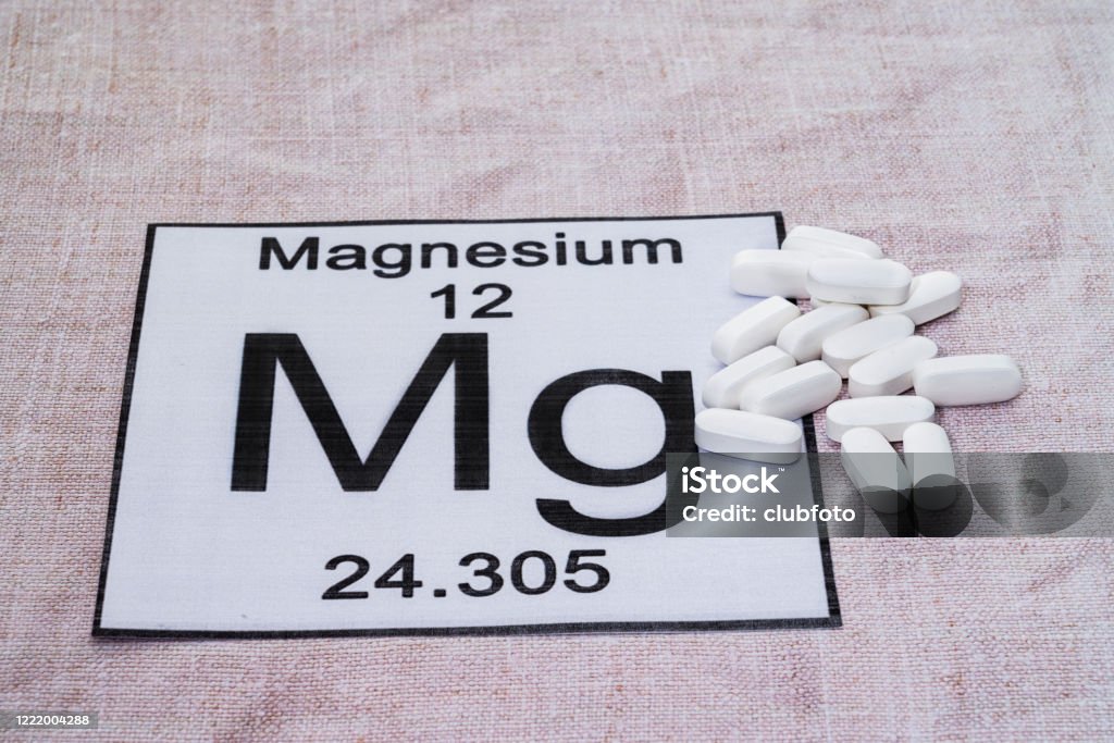 Magnesium supplement pills Magnesium supplement pills placed on a Periodic table tile Magnesium Stock Photo