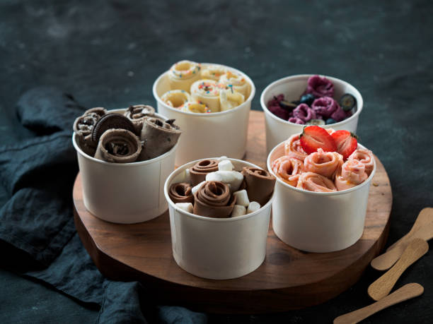 rolled ice creams in cone cups on dark background