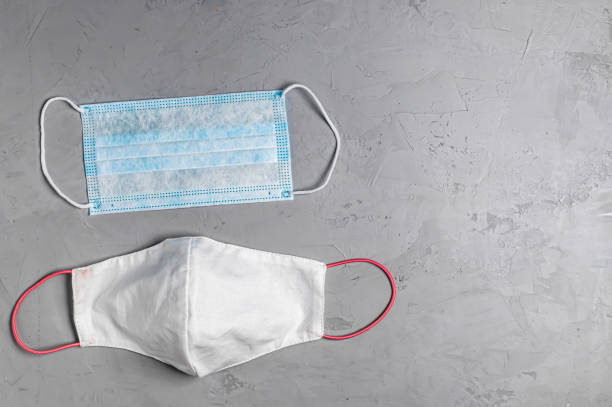 istock disposable blue mask and reusable mask on a grey concrete background 1222004532