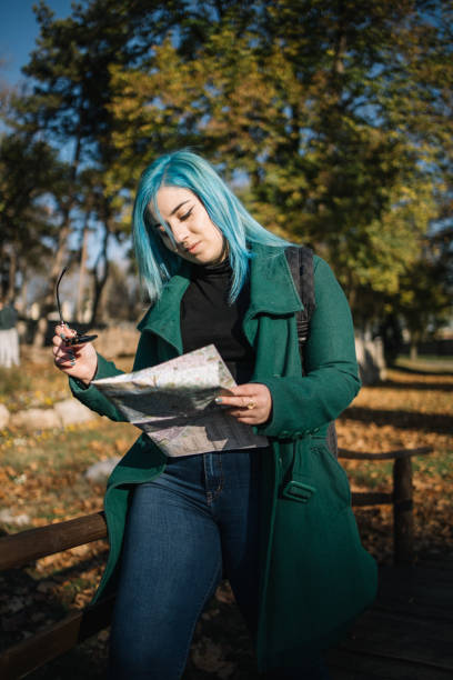 istock Girl looking a map while sitting on wooden fence 1222005776
