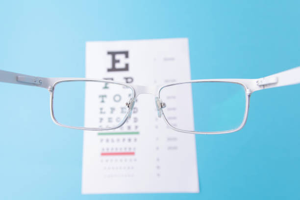 istock Hand-held White glasses, view of the Snellen chart. Blue background 1222005895