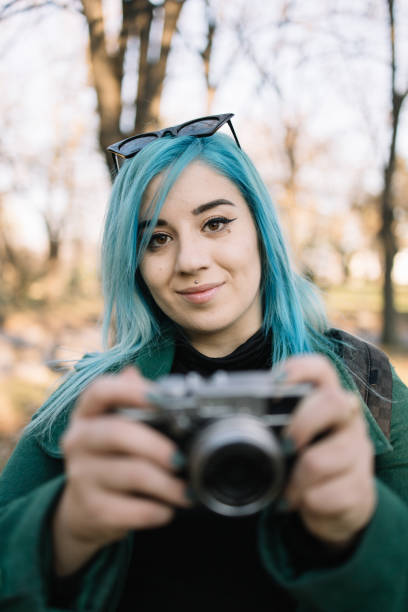 istock Woman holding blurred photo camera and looking front 1222007210