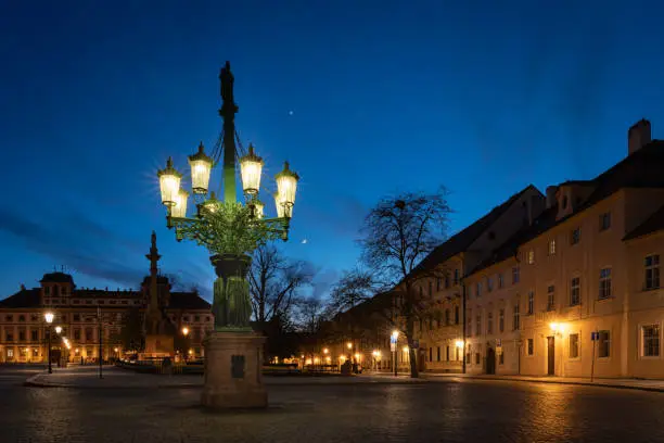 Photo of Historic gas street lamp on a Castle square in Prague, Czech Republic. Beautiful ornamental candelabra with 8 arms, technical monument made of cast iron in 1876