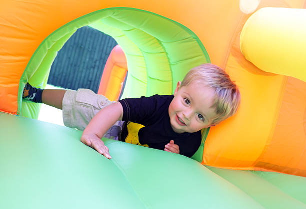 criança no castelo insuflável - inflatable child jumping leisure games imagens e fotografias de stock