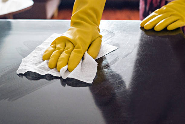 istock Woman cleaning the table surface with protective gloves 1222009840