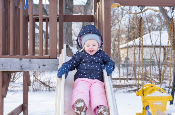 istock Happy Girl Sliding In Park During Winter 1222009904