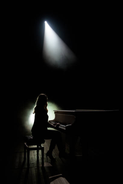 istock Female keyboards player on stage during concert, backlight 1222011484