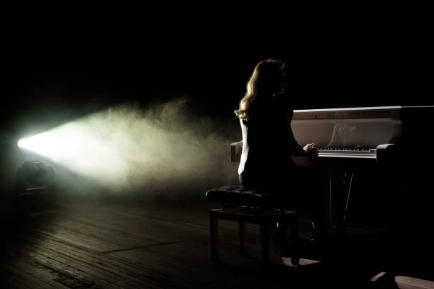 istock Female keyboards player on stage during concert, backlight 1222011511