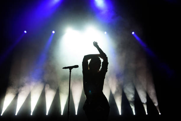 silueta de cantante en el escenario. fondo oscuro, humo, focos - concierto de música pop fotografías e imágenes de stock