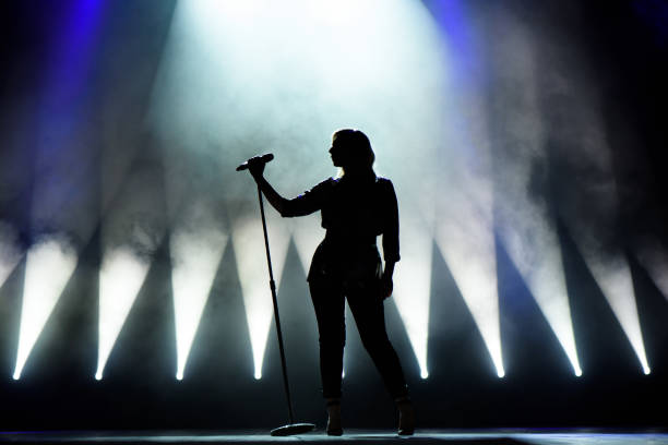 vocalista cantando al micrófono. cantante en silueta - performer fotografías e imágenes de stock