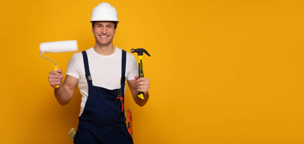 istock Construction worker. Close-up photo of overjoyed construction worker, who is looking in the camera with a big smile, while holding several building tools in his hands. 1222012215