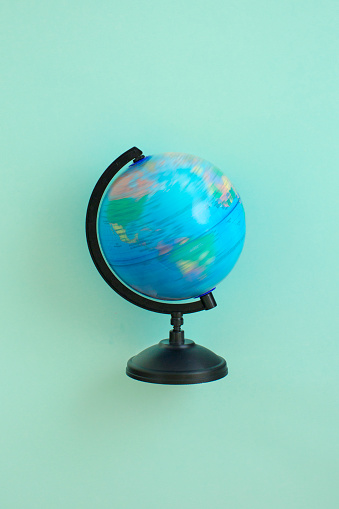 Desk top spinning globe on green background