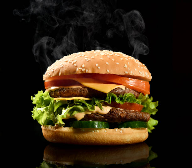 istock Double burger cheeseburger barbeque sandwich with beef  cheese and fresh vegetables hot with steam smoke on black 1222012986