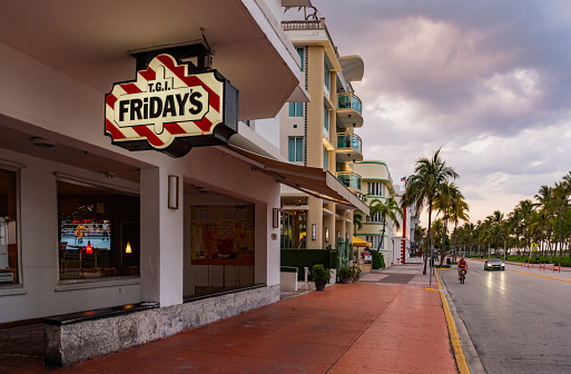 In Miami Beach, United States a TGI Fridays chain restaurant on Ocean Drive keeps their signage illuminated as the restaurant remains open for business during the Coronavirus pandemic.