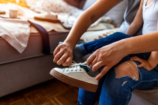 istock Mother Helping Her Son To Tie His Shoes 1222015069